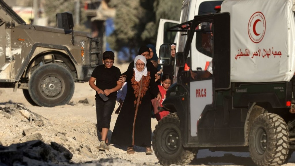Tulkerim şehri yakınlarındaki Nur Şems mülteci kampına yönelik bombardımandan kaçan Filistinli bir aile, kampın dışında konuşlanmış Kızılay ambulansının önünden geçiyor. Batı Şeria, Ağustos 2024. Fotoğraf: Cafer Ashtiyeh, AFP.