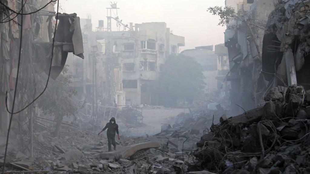 Bir adam, Gazze Şeridi'nin orta kesimindeki Bureyc Mülteci Kampı'nda, İsrail hava saldırılarında yıkılan binaların enkazı arasında yürüyor, 12 Ocak 2025. Fotoğraf: Eyad Baba, AFP, Getty Images.